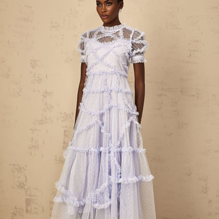Woman wearing long blue maxi dress with white polka dots and ruffled tulle details
