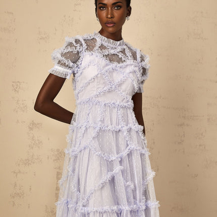 Woman wearing long blue maxi dress with white polka dots and ruffled tulle details