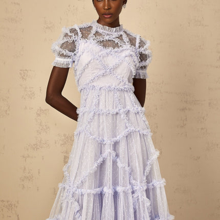 Woman wearing long blue maxi dress with white polka dots and ruffled tulle details