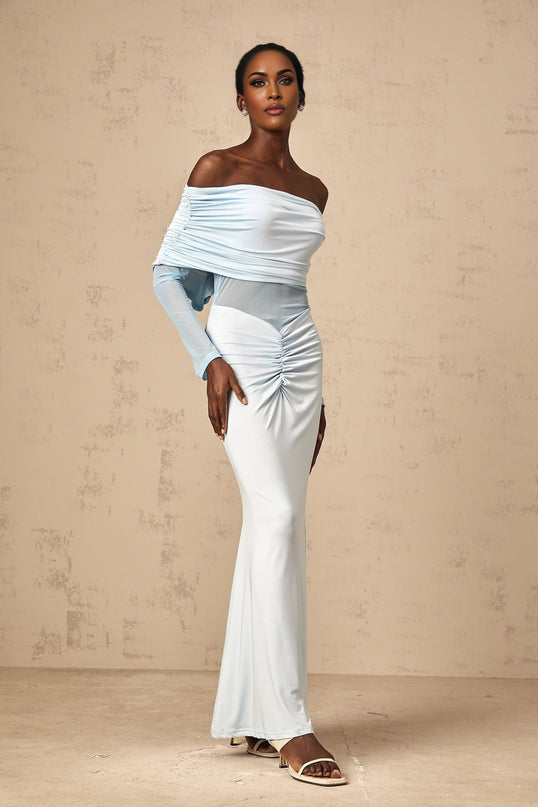 Woman wearing long blue offshoulder dress with ruched details and flowing maxi skirt