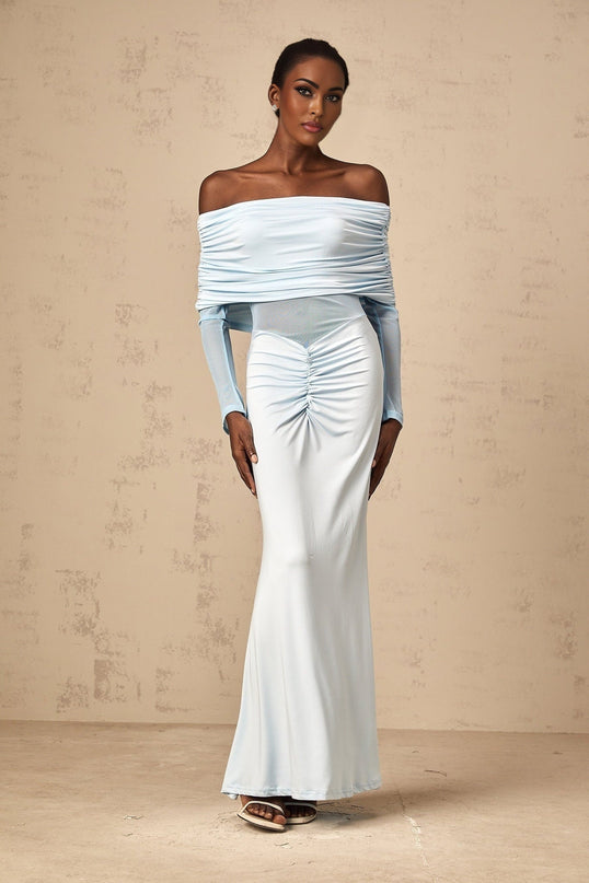Woman wearing long blue offshoulder dress with ruched details and flowing maxi skirt