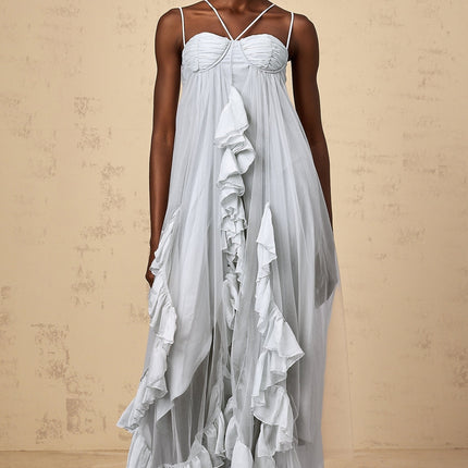 Woman wearing long blue tulle maxi dress with layered ruffles and flowing skirt