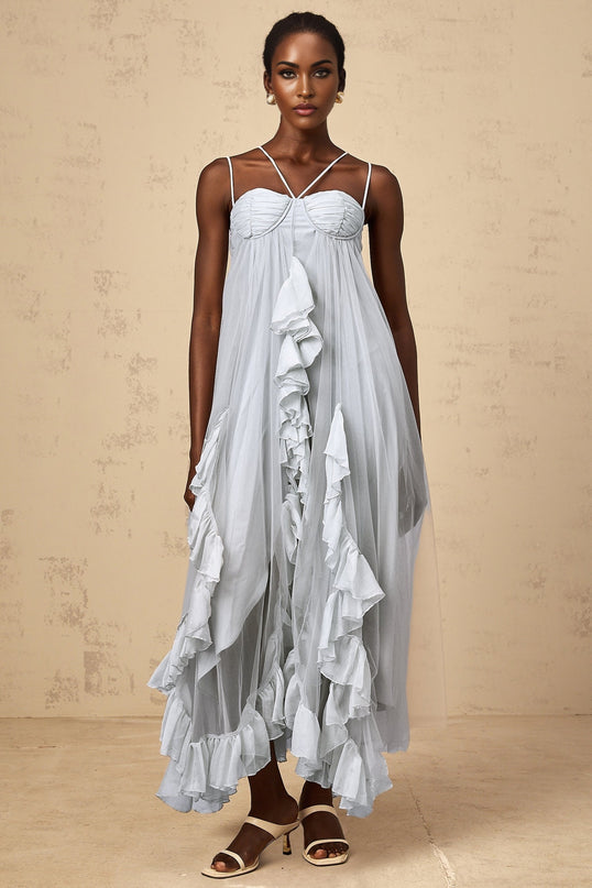 Woman wearing long blue tulle maxi dress with layered ruffles and flowing skirt