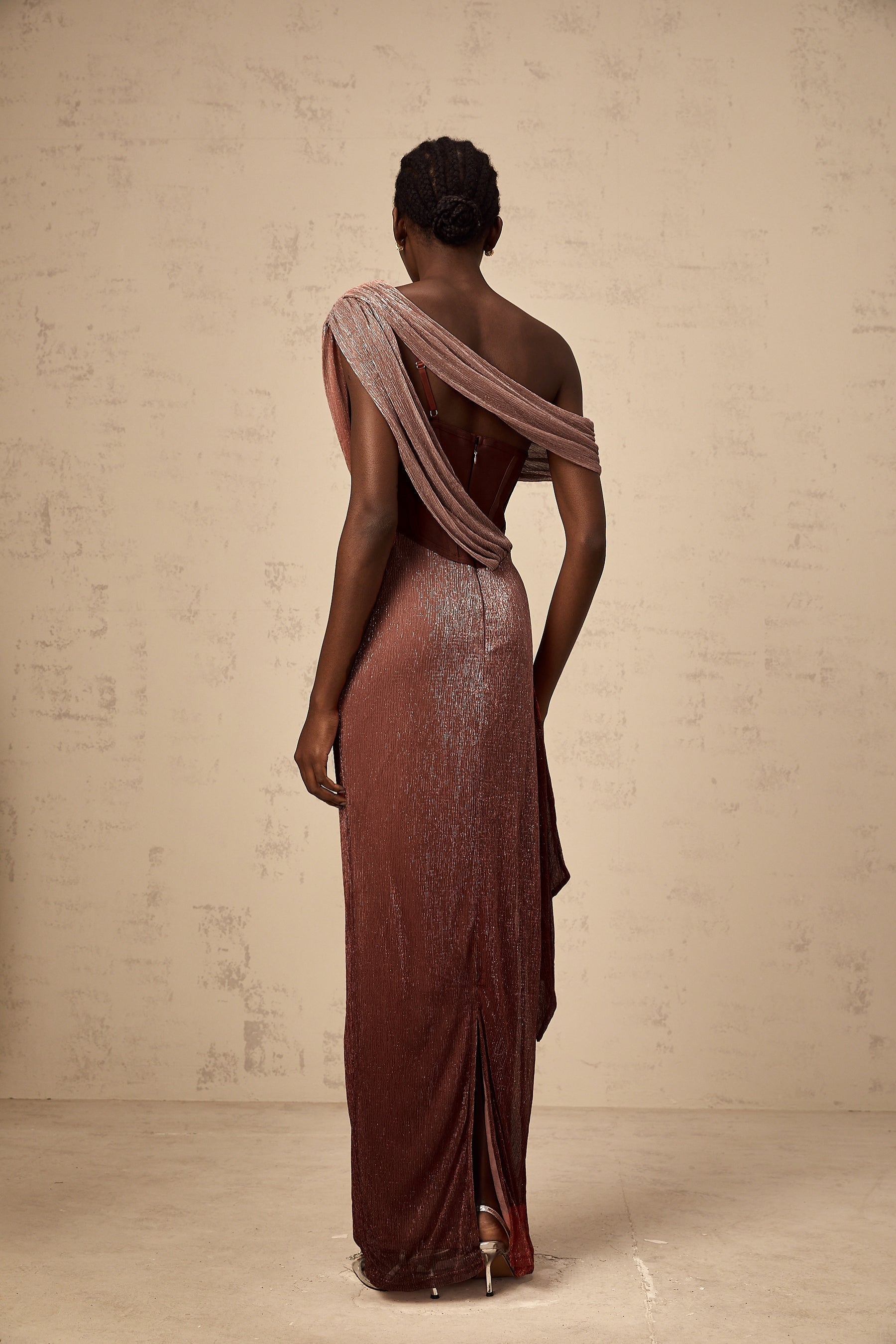 Woman wearing long brown maxi dress with corset top and ribbon design details flowing skirt elegant formal style