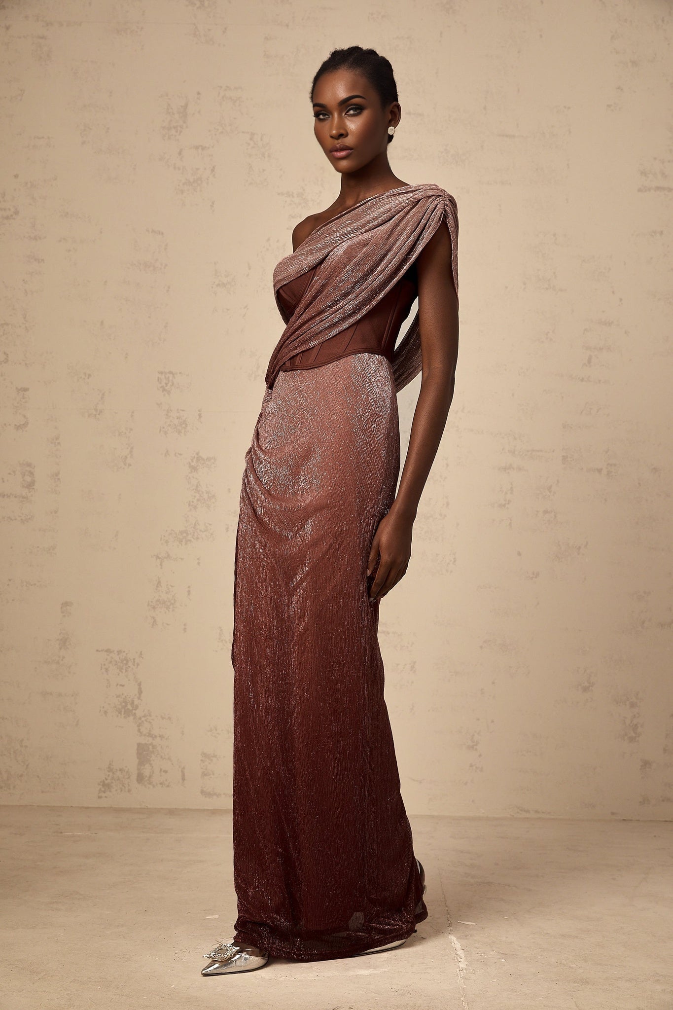 Woman wearing long brown maxi dress with corset top featuring ribbon design and flared skirt
