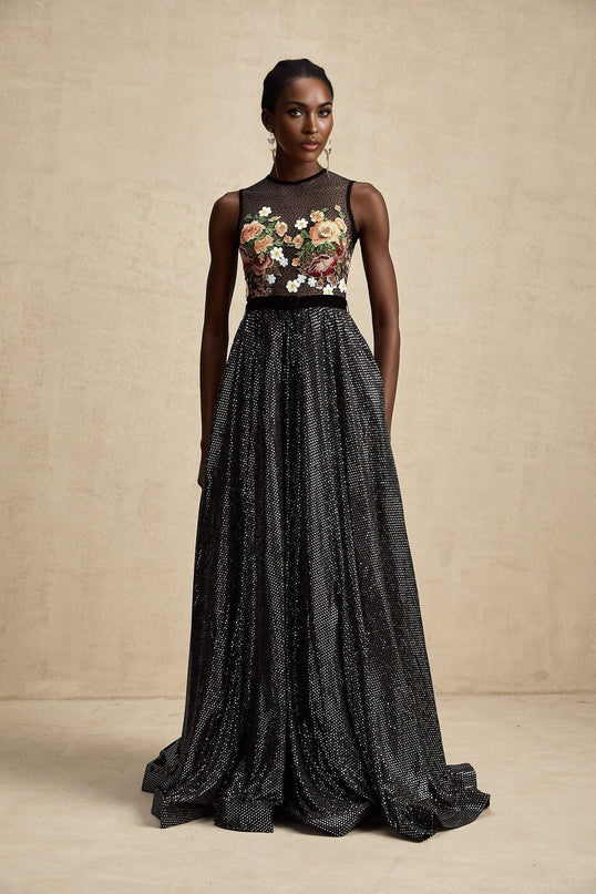 Woman wearing long floral embroidered maxi dress with white background