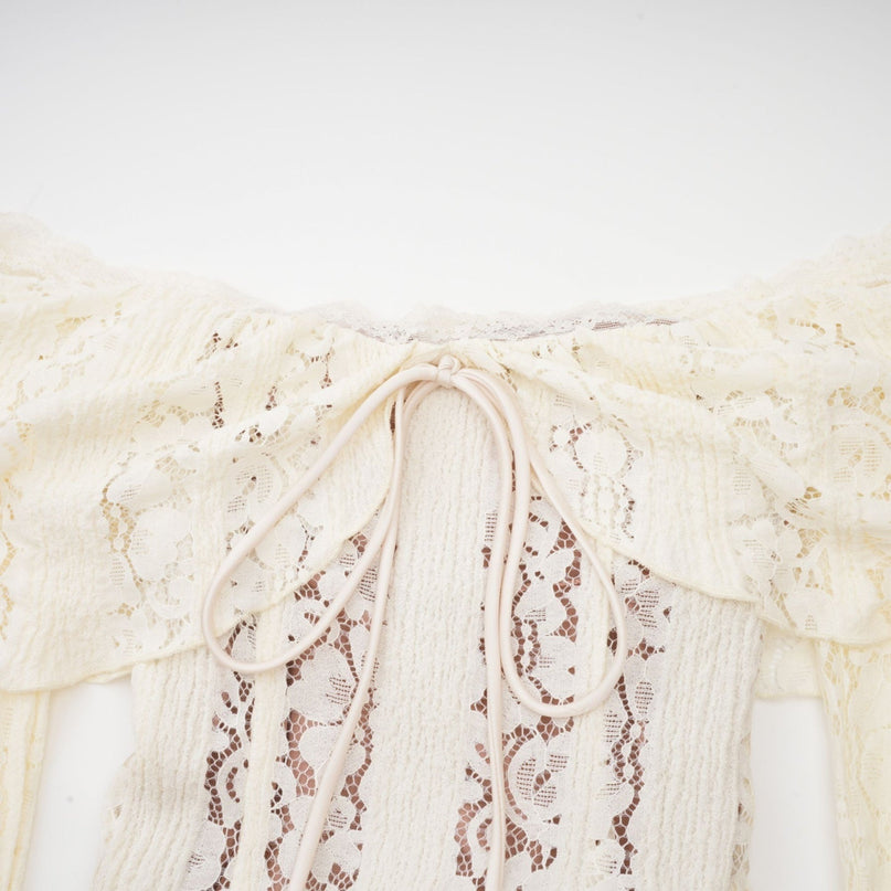 Woman wearing long floral lace maxi dress with train in neutral color standing elegantly