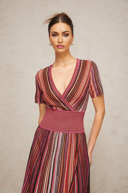 Woman wearing long flowing multicolor metallic knit maxi dress with shimmering fabric and sleeveless design