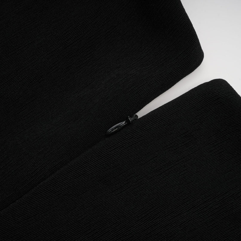 Woman wearing long flowy maxi dress with contrasting colors and v neckline featuring decorative bow detail