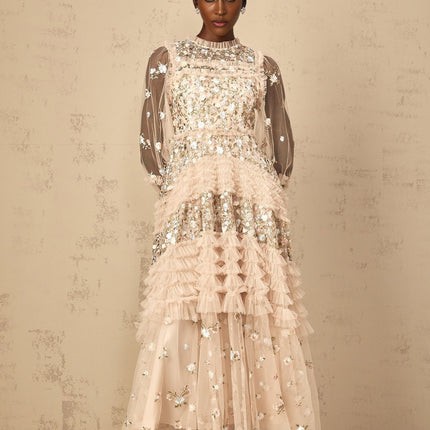 Woman wearing long flowy maxi dress with floral embroidery and tiered tulle skirt