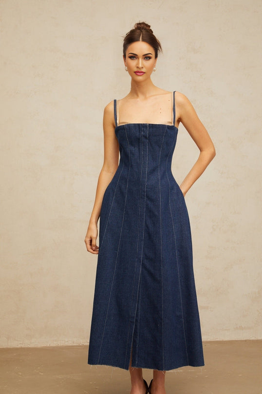Woman wearing long indigo blue denim dress with paneled design and midi length