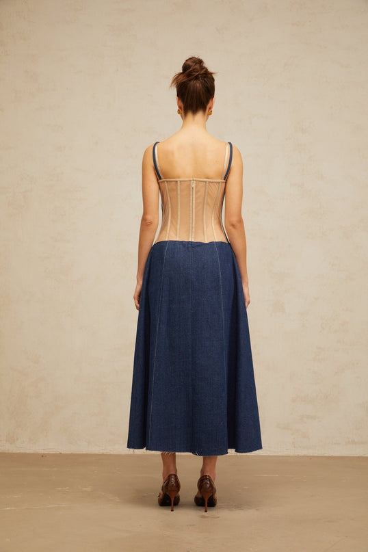 Woman wearing long indigo blue denim dress with panelled design and midi length