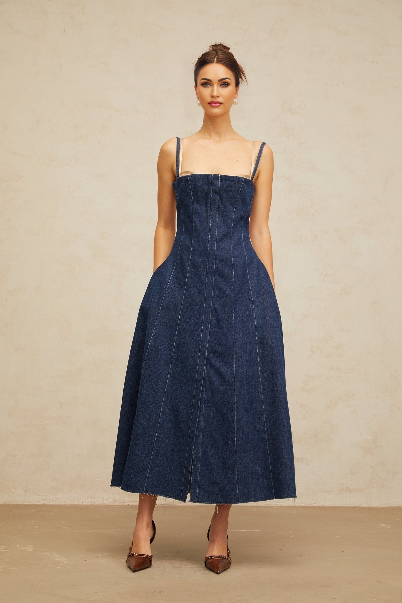 Woman wearing long indigo blue denim dress with panels and midi length