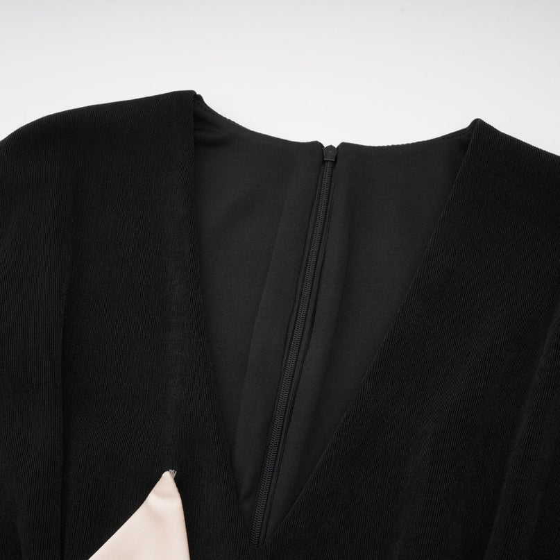 Woman wearing long maxi dress with contrasting color bowknot detail at vneck dark bodice and light flowy skirt