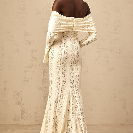 Woman wearing long neutral colored floral lace maxi dress with train design