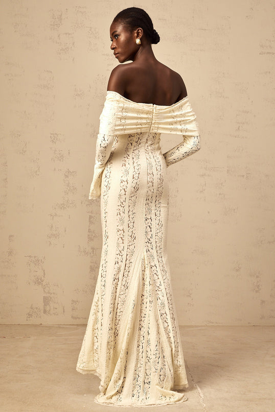 Woman wearing long neutral colored floral lace maxi dress with train design