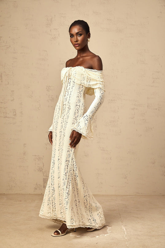 Woman wearing long neutral colored floral lace maxi dress with train design