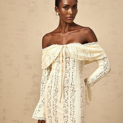 Woman wearing long neutral colored floral lace maxi dress with train design