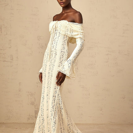 Woman wearing long neutral colored floral lace maxi dress with train design