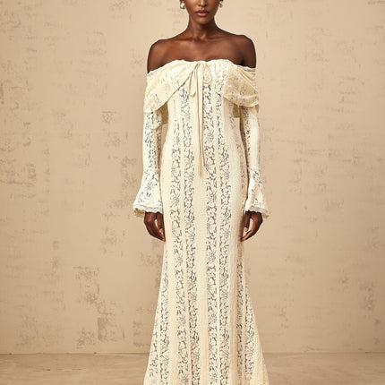 Woman wearing long neutral colored floral lace maxi dress with train design