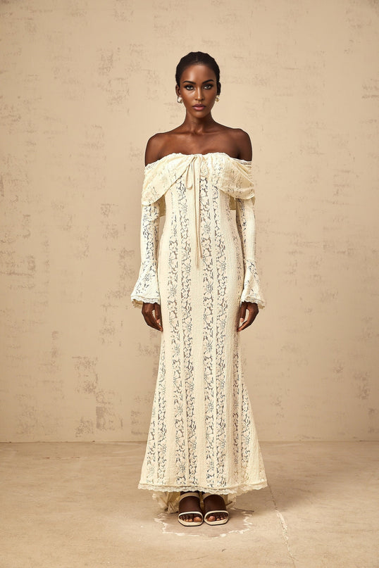 Woman wearing long neutral colored floral lace maxi dress with train design