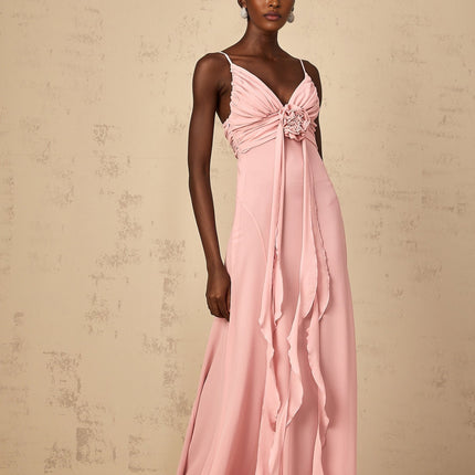 Woman wearing long pink maxi dress with 3D floral petal details on tulle fabric