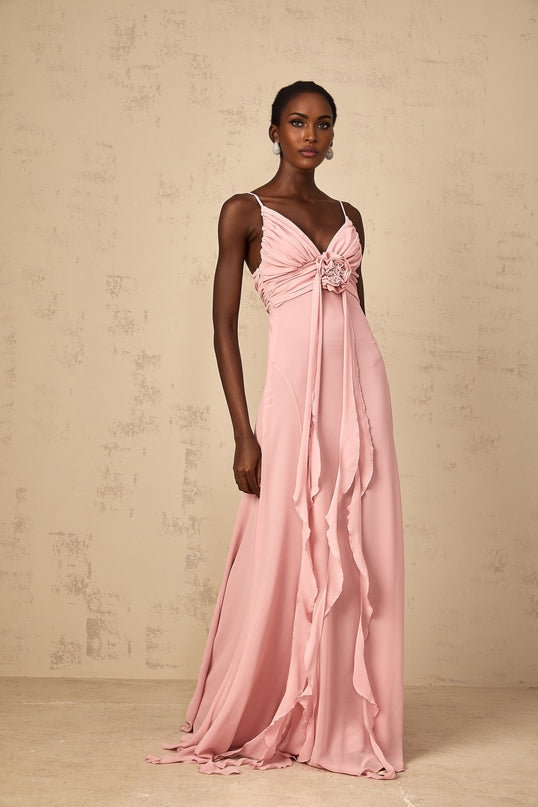 Woman wearing long pink maxi dress with 3D floral petal details on tulle fabric