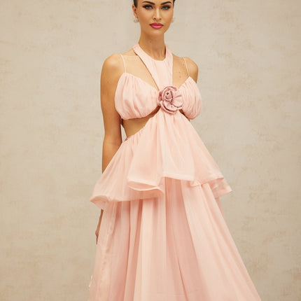 Woman wearing long pink maxi dress with floral applique details and cutout sections