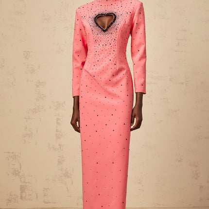 Woman wearing long pink maxi dress with heart shaped cutout and embellishments