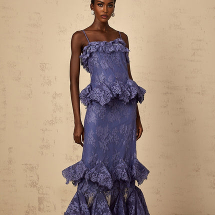 Woman wearing long purple floral lace maxi dress with ruffled details and flowing skirt