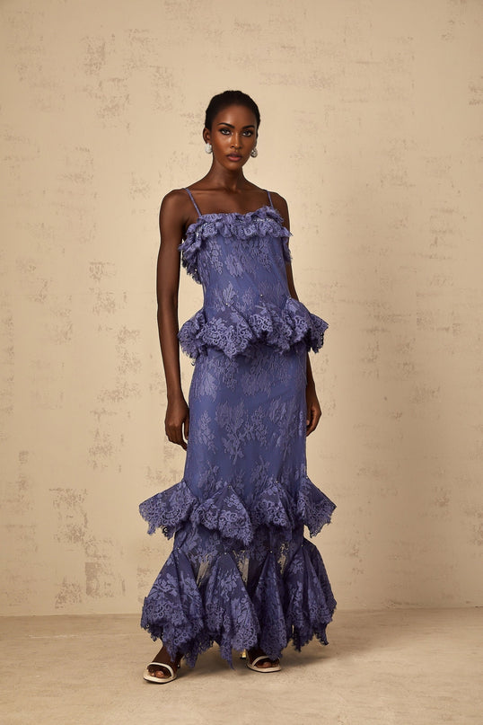 Woman wearing long purple floral lace maxi dress with ruffled details and flowing skirt