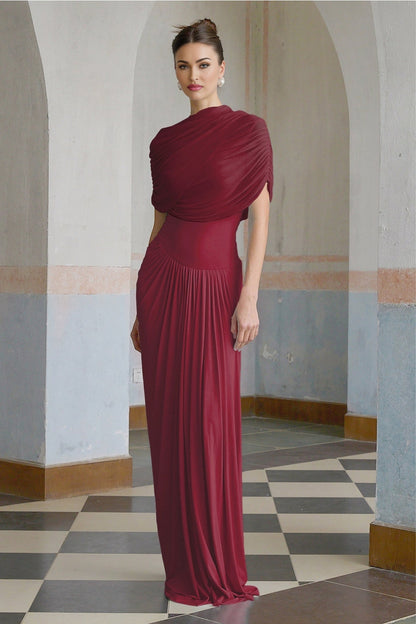 Woman wearing long red asymmetric pleated maxi dress with one shoulder strap