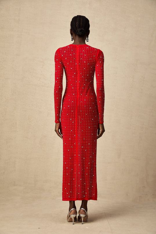 Woman wearing long red tulle dress with rhinestone embellishments and flowing skirt