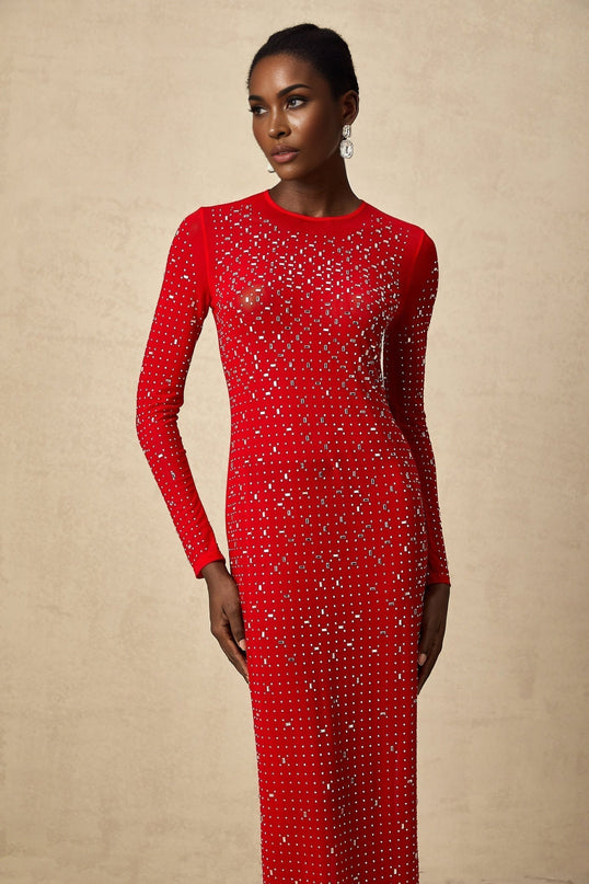 Woman wearing long red tulle maxi dress with rhinestone embellishments and flowing skirt