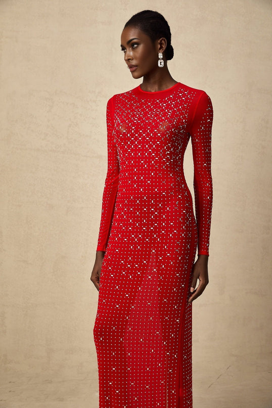 Woman wearing long red tulle maxi dress with rhinestone embellishments and flowing skirt