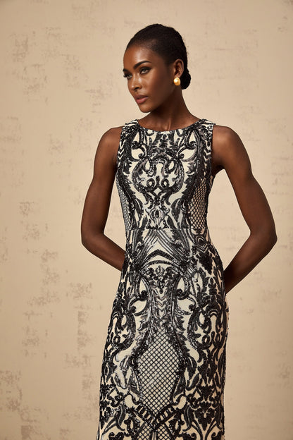 Woman wearing long silver sparkly dress with sheer mesh overlay and sequin embellishments full length view