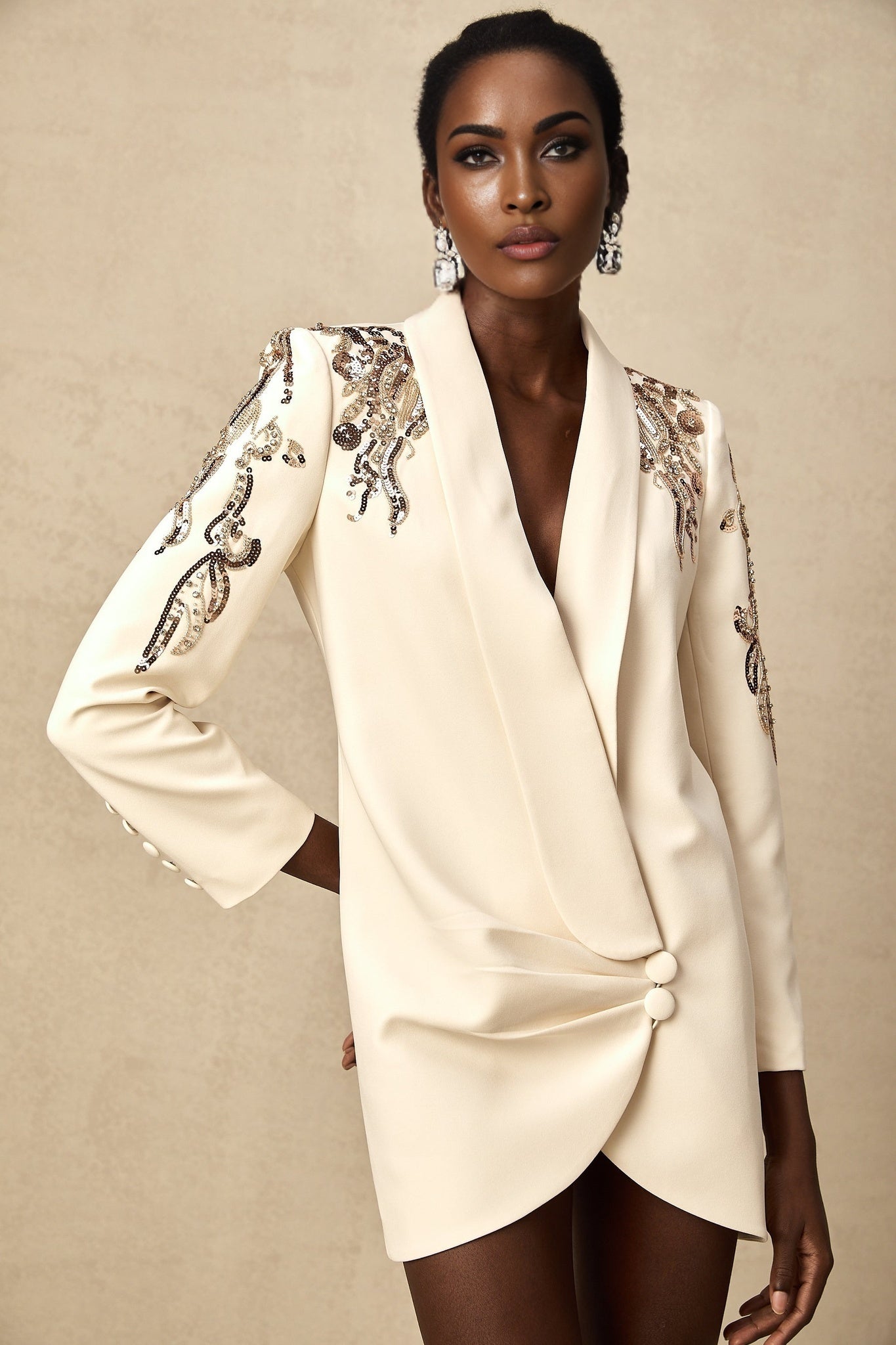 Woman wearing long sleeve black blazer dress covered in shiny sequins