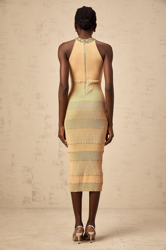 Woman wearing long sleeve sequined midi dress in ribbed knit fabric with sparkly finish and form fitting silhouette