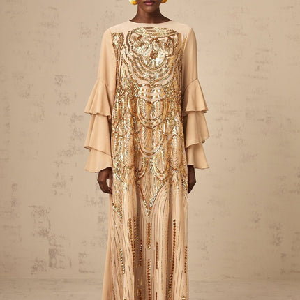 Woman wearing long sparkly formal dress with ruffled sleeves and tulle skirt