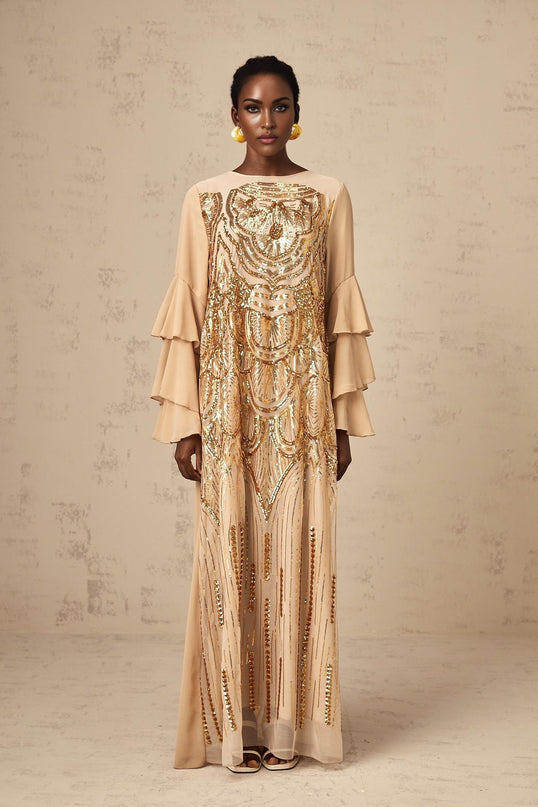 Woman wearing long sparkly formal dress with ruffled sleeves and tulle skirt