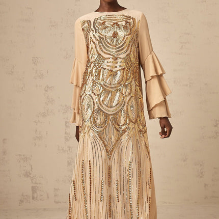 Woman wearing long sparkly tulle dress with ruffled sleeves and sequin details