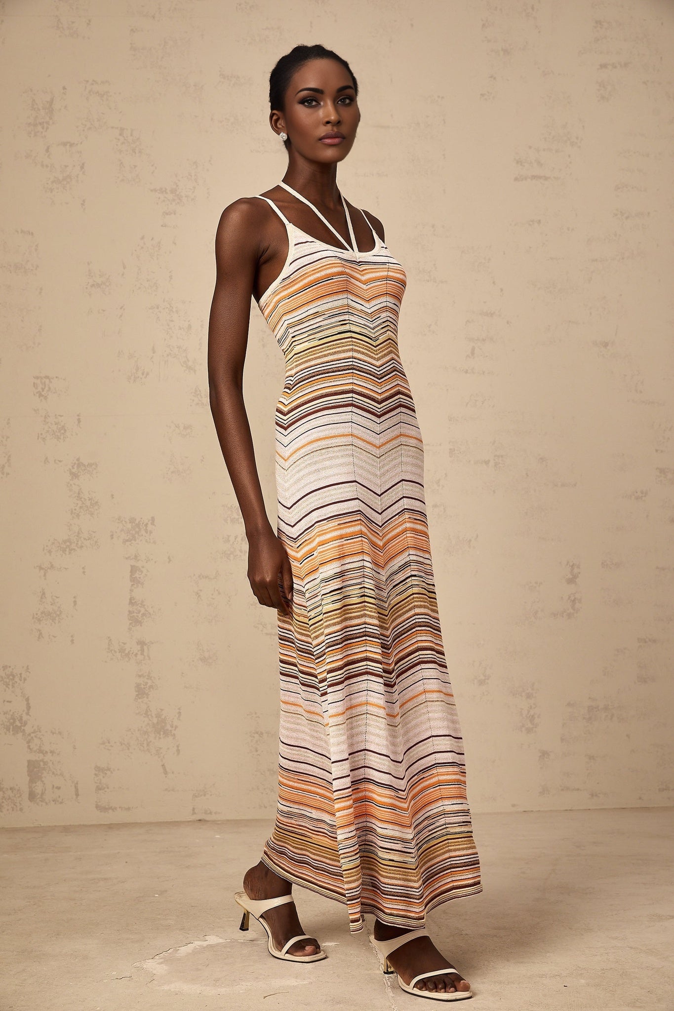 Woman wearing long striped knit maxi dress in multiple colors by Chloe