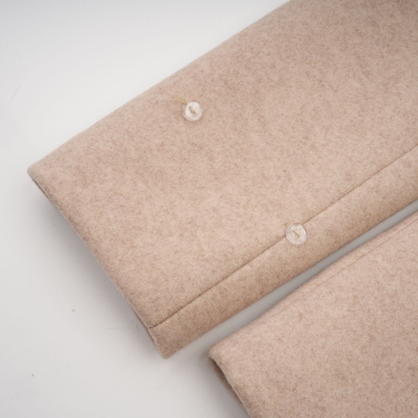 Woman wearing long white faux fur coat with detachable cape over shoulders