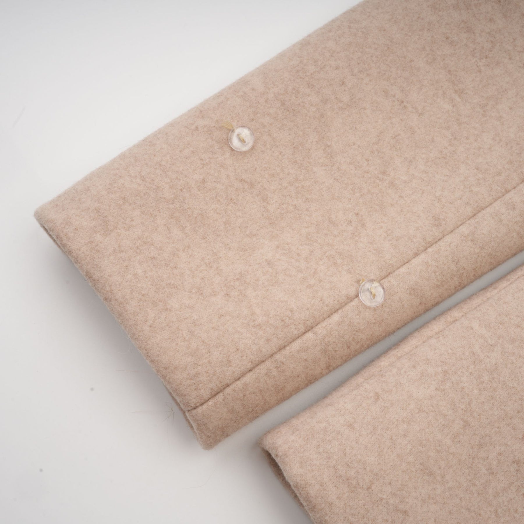 Woman wearing long white faux fur coat with detachable cape over shoulders