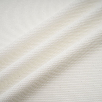 Woman wearing long white knit dress with glittery floral applique details