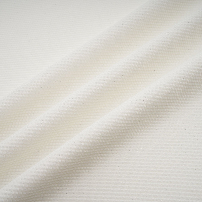 Woman wearing long white knit dress with glittery floral applique details