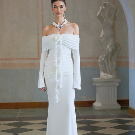 Woman wearing long white knit dress with glittery floral appliques standing in elegant pose