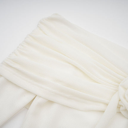 Woman wearing long white knit dress with glittery floral appliques