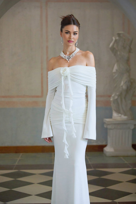 Woman wearing long white knit dress with glittery floral appliques