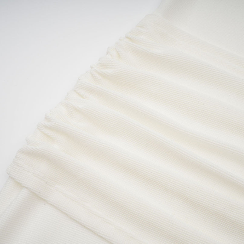 Woman wearing long white knit maxi dress with glittery floral appliques